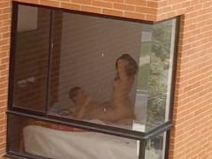 Imágenes reales de una pareja cachonda teniendo sexo en su cama con la cortina abierta, estaban tan concentrados en tener sexo que ni siquiera les importó que otras personas estuvieran viendo el sexo amateur.