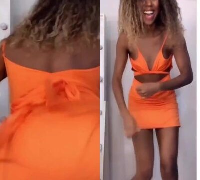 Una morena de pelo rizado bailando con un vestido