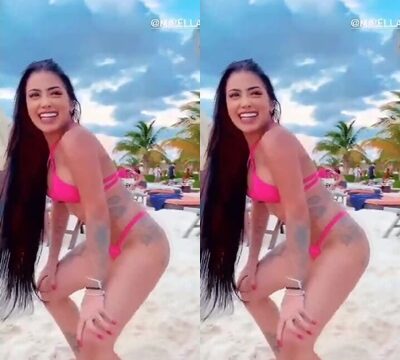 Una mujer morena bailando en bikini rosa