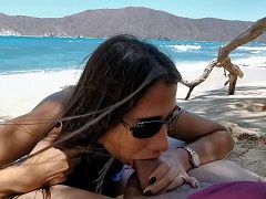 Morena latina chupando en plena playa
